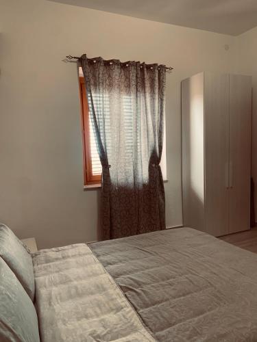 a bedroom with a bed and a window at Casa Vacanza Elena in Capo dʼOrlando