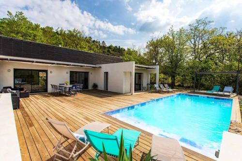 una gran piscina en una terraza de madera con sillas en Villa Blanche, Contemporary, Cathars, Couiza, Carcassonne, en Couiza