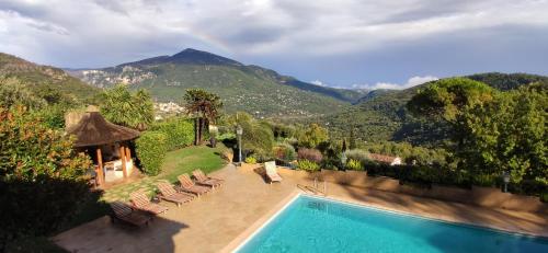 a resort with a swimming pool and mountains in the background at Loup Castel Boutique Hotel B&B in Le Bar-sur-Loup