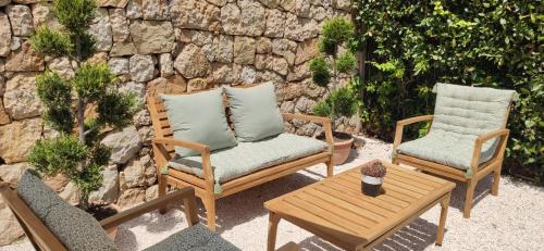 a patio with two chairs and a table and a stone wall at Loup Castel Boutique Hotel B&B in Le Bar-sur-Loup