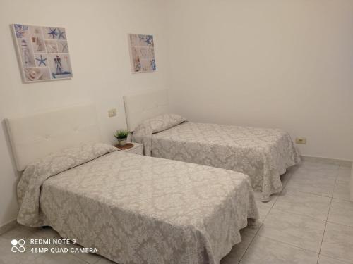 two beds in a room with two beds sidx sidx sidx sidx at Apartamento con vistas en Raxó in Raxo