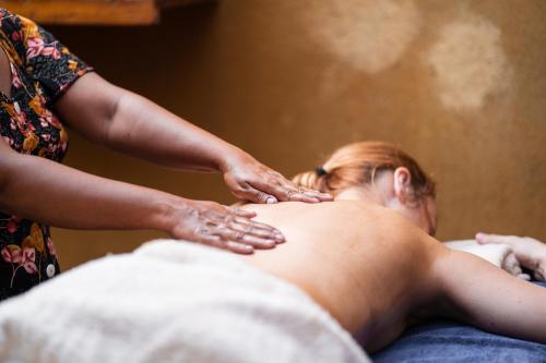 a woman getting a massage from a man on a bed at Happy Man Village in Bentota