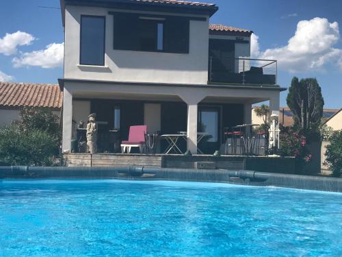 une maison avec une piscine devant une maison dans l'établissement Maison de vacances en Camargue, à Marsillargues