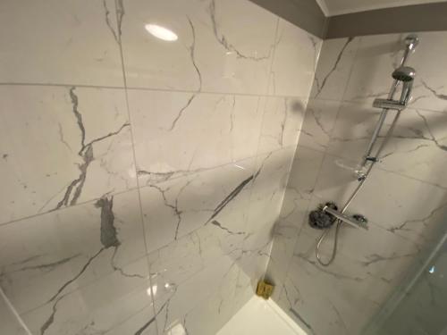 bagno con box doccia in marmo bianco e doccia di L09 - The Snowdon Spa with Hot Tub a Bethesda