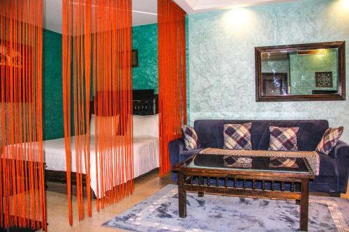 - un salon avec un canapé et un lit dans l'établissement BAGATELLE STUDIO GUELIZ, à Marrakech