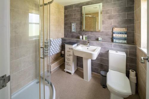 a bathroom with a sink and a toilet and a shower at Osbornes Holiday House near Exeter with swimming pool in Exeter