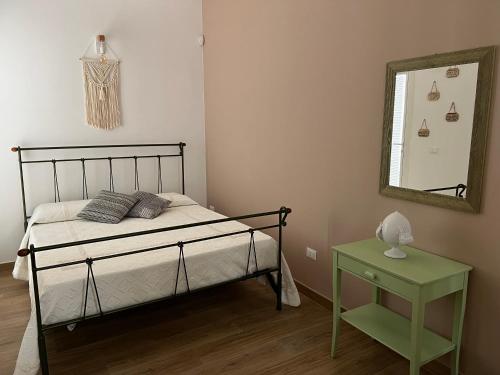 Schlafzimmer mit einem Bett, einem Spiegel und einem Tisch in der Unterkunft Tavernetta Open space in Specchia