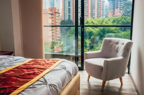 1 dormitorio con 1 cama, 1 silla y 1 ventana en Poblado, Great Location, Luxury building, en Medellín