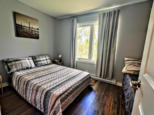 a bedroom with a bed and a window at Salmon River Motel in Shannonville