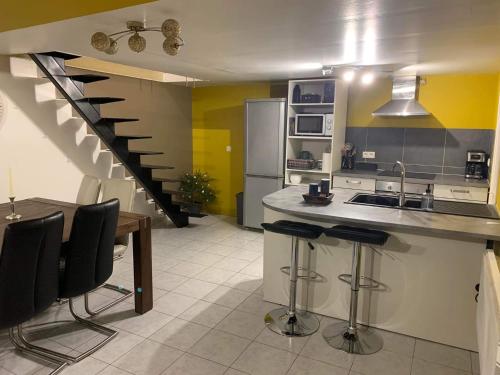 une cuisine avec un comptoir, des chaises et un escalier dans l'établissement Rocroi: Gîte de Bourgogne, à Rocroi