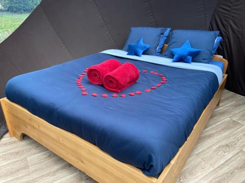 a bed with two red roses on top of it at Bulle d Evasion Silly près de Pairi Daiza in Silly