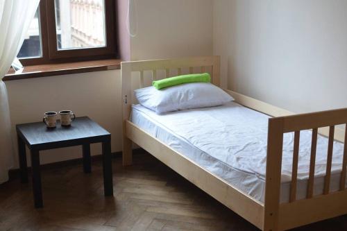 a bedroom with a bed and a table and a window at Rooms in the center of Lviv in Lviv