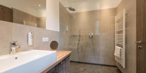 a bathroom with a sink and a shower at Hotel Rosengarten in Nova Levante
