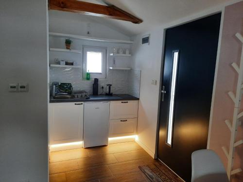 cocina con armarios blancos, fregadero y ventana en Apartament na górce, en Uherce Mineralne