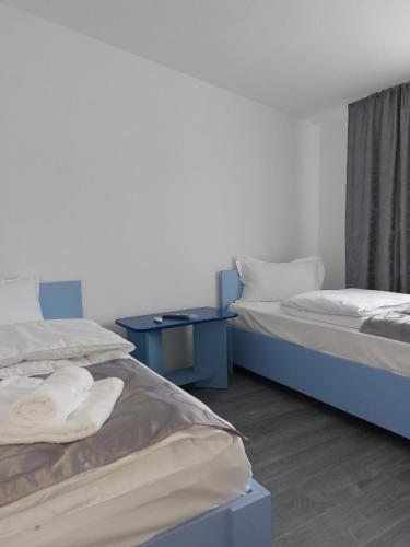 two beds sitting next to each other in a room at La Maria in Şuncuiuş