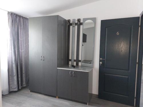 a room with a black cabinet and a mirror at La Maria in Şuncuiuş