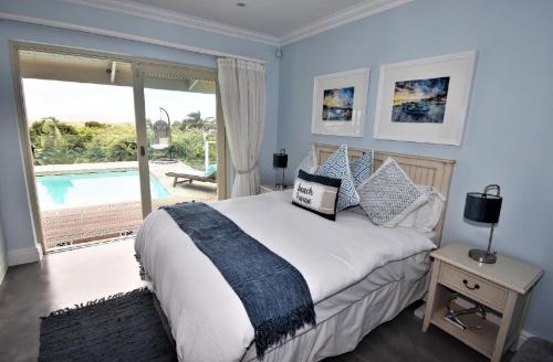 a bedroom with a large bed with a view of a pool at Lasalle holiday home (Sun, Beach, Views, Fun for everyone!) in Plettenberg Bay