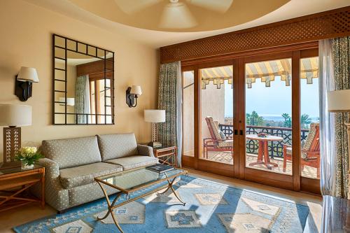 a living room with a couch and a balcony at Four Seasons Resort Sharm El Sheikh in Sharm El Sheikh