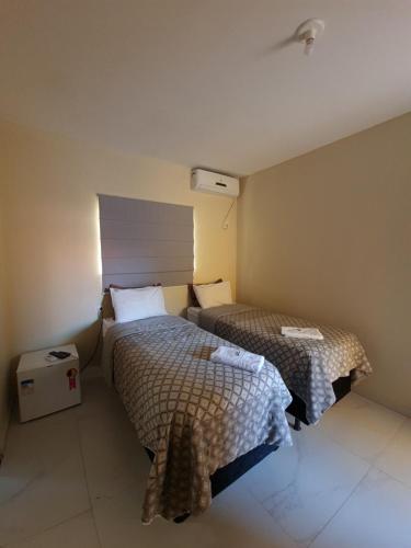 a hotel room with two beds and a heater at Pousada Quatro Estações in Alto Paraíso de Goiás
