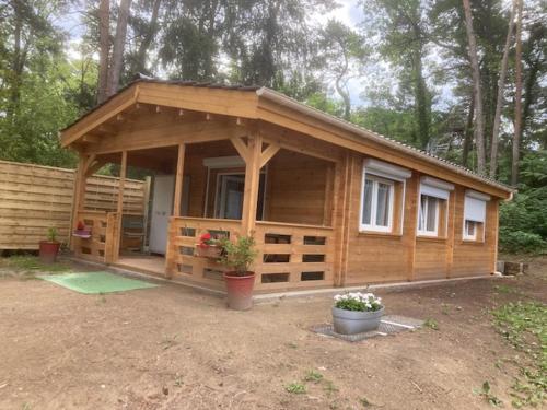 Cabaña de madera grande con porche en el bosque en Les Pins, en Excenevex