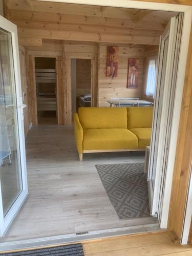 ein Wohnzimmer mit gelber Couch in einem Haus in der Unterkunft Les Pins in Excenevex