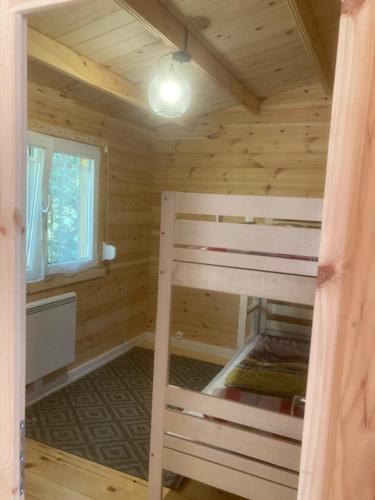 1 dormitorio con litera en una cabaña de madera en Les Pins, en Excenevex