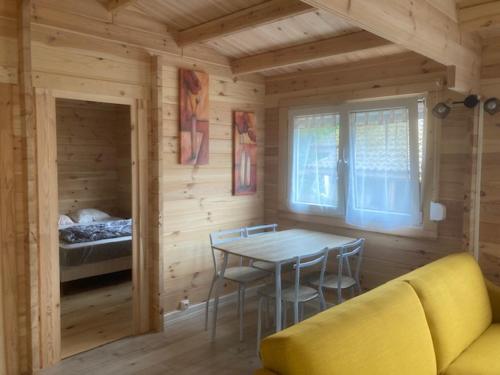 ein Esszimmer mit einem Tisch und Stühlen in einer Hütte in der Unterkunft Les Pins in Excenevex