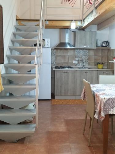 a spiral staircase in a kitchen with a table at La casa di Anita nel cuore di Segesta in Calatafimi