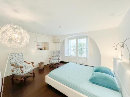 a bedroom with a bed and two chairs and a chandelier at Appartement 2 chambres avec Terrassse en Hyper centre in Bordeaux