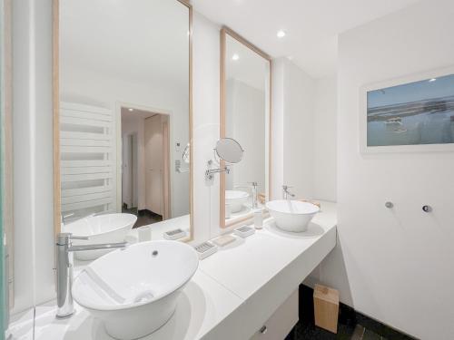 a white bathroom with two sinks and two mirrors at Appartement 2 chambres avec Terrassse en Hyper centre in Bordeaux