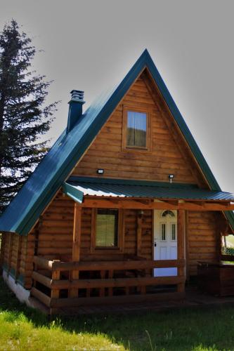 eine Blockhütte mit blauem Dach in der Unterkunft Log - cabin HOPE in Žabljak