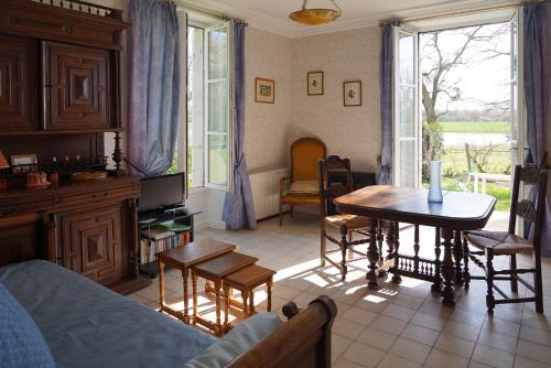 un salon avec un canapé, une table et des chaises dans l'établissement Appartements détente & nature - Domaine de La Thiau, à Briare
