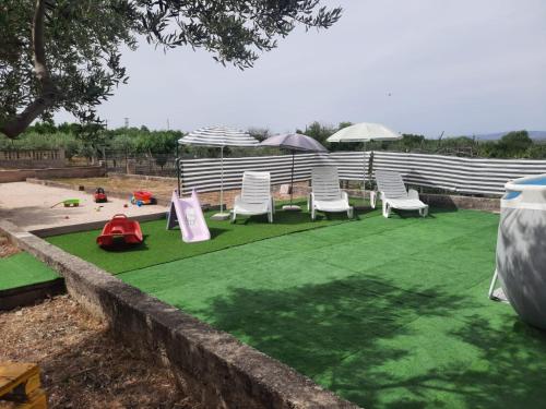 um grupo de cadeiras de jardim e guarda-sóis num campo em Apartman Stipe em Gaćelezi