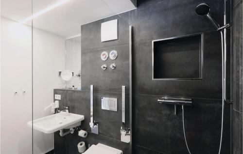 a black and white bathroom with a sink and a shower at Baltic in Binz
