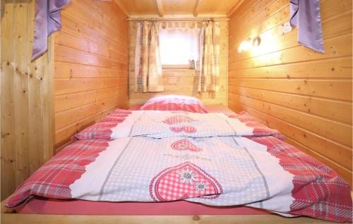 a bed in a wooden cabin with a quilt on it at Amazing Home In Vordernberg With House A Mountain View in Vordernberg