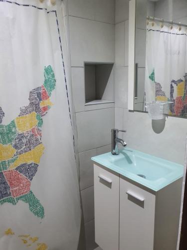 a bathroom with a sink and a shower curtain at Sea breeze vacation ll en Condominio Verde Mar in San Juan