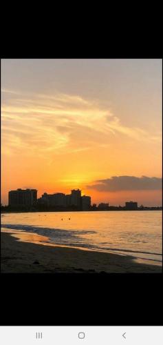 a sunset over the ocean with a beach and buildings at Sea breeze vacation ll en Condominio Verde Mar in San Juan