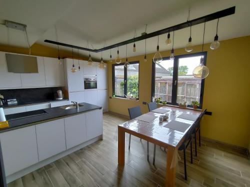 a kitchen with a table and a dining room at Mote26 in Ingooigem