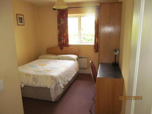 a small bedroom with a bed and a window at Holiday Home Tralee Ireland in Tralee