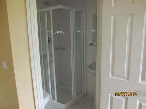 a glass shower in a bathroom with a sink at Holiday Home Tralee Ireland in Tralee