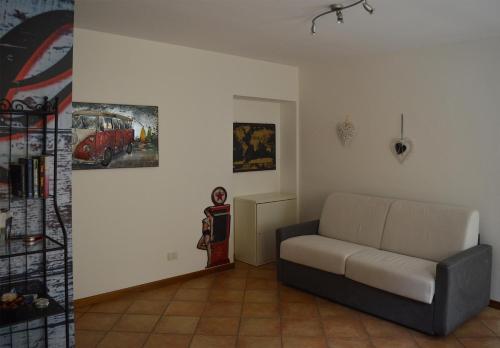 a living room with a couch and paintings on the wall at Da Sid in Tremezzo