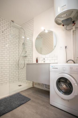 La salle de bains blanche est pourvue d'un lave-linge et d'une douche. dans l'établissement Appartement T2 hyper centre à Périgueux 1 chambre Lou Chabrol, à Périgueux