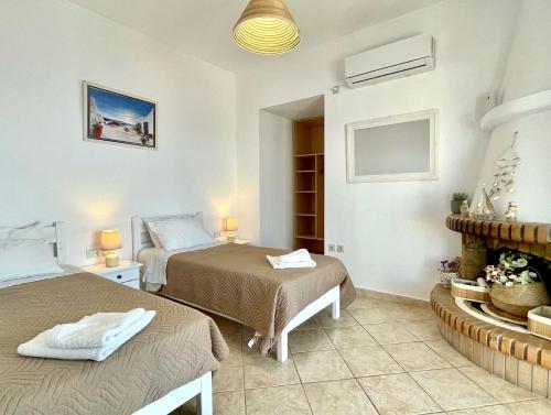 1 dormitorio con 2 camas y chimenea en Villa Meganisi, en Agios Nikolaos
