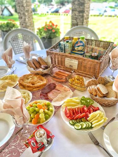 Una mesa cubierta con platos de comida y cestas de comida. en Auróra Rendezvényterem & Szállás, en Jászapáti