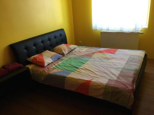 a bed with a colorful quilt on it in a room at 2 Kambariu butas.Apartments-in the city UKMERGE. in Ukmergė
