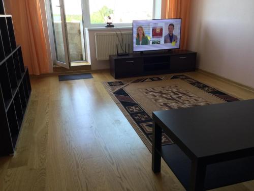 a living room with a table and a tv in it at 2 Kambariu butas.Apartments-in the city UKMERGE. in Ukmergė