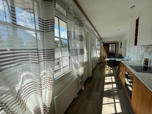 una cocina con una ventana grande con cortinas. en Moderne einzigartige Wohnung in Altdorf, en Altdorf