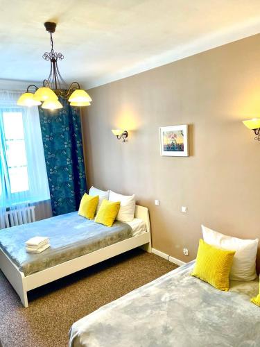 1 dormitorio con 2 camas con almohadas amarillas en BackPack Apart Rooms en Varsovia