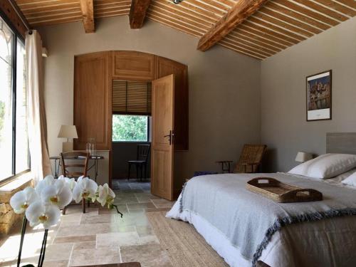 a bedroom with a bed and a table and a window at LES BARTAVELLES in Aix-en-Provence