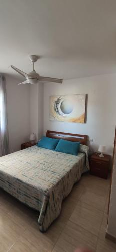 1 dormitorio con cama con almohadas azules y techo en Costa Marina I, 1ª linea, 4ª planta, Norte, en Oropesa del Mar